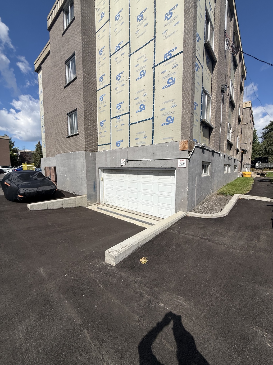 Vue d’ensemble d’une entrée de garage avec bordures de béton, caniveaux et pavage à Rivière-des-Prairies